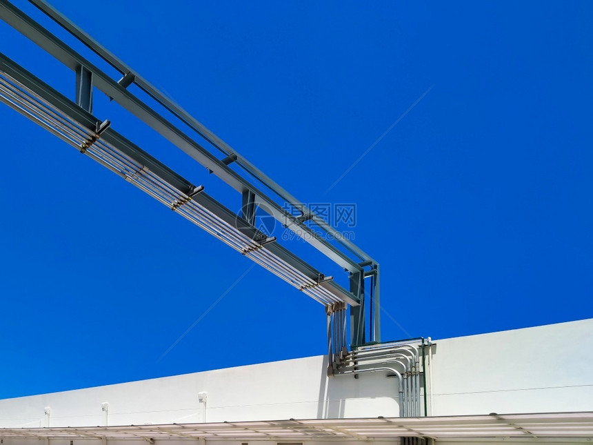 结构体高架以蓝色清晰天空背景将室外气管道系统低角度视图进入白色建筑的蓝光天空背景安装图片