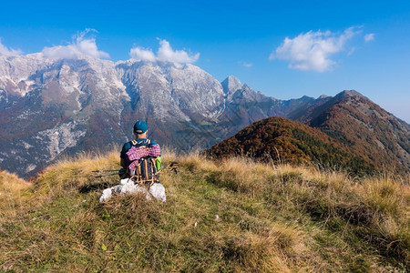 逗留步行在山顶的秋天人类登山者坐着看地风景纳达林背包背景