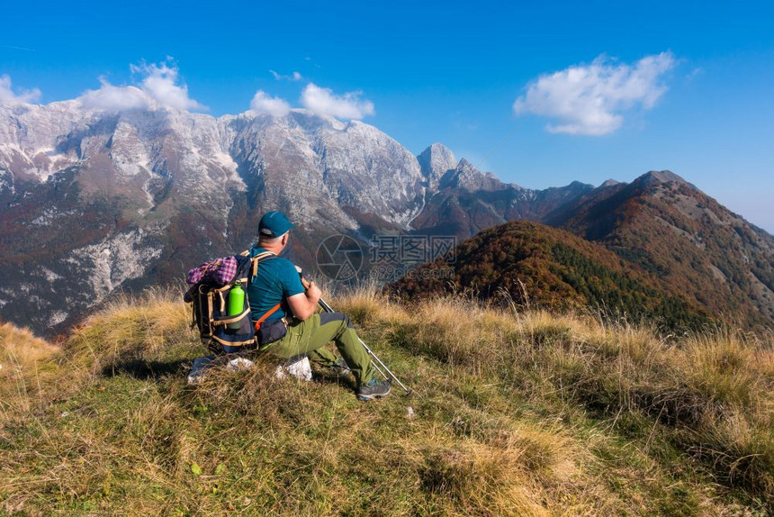 户外逗留在山顶的秋天人类登山者坐着看地风景岩石图片