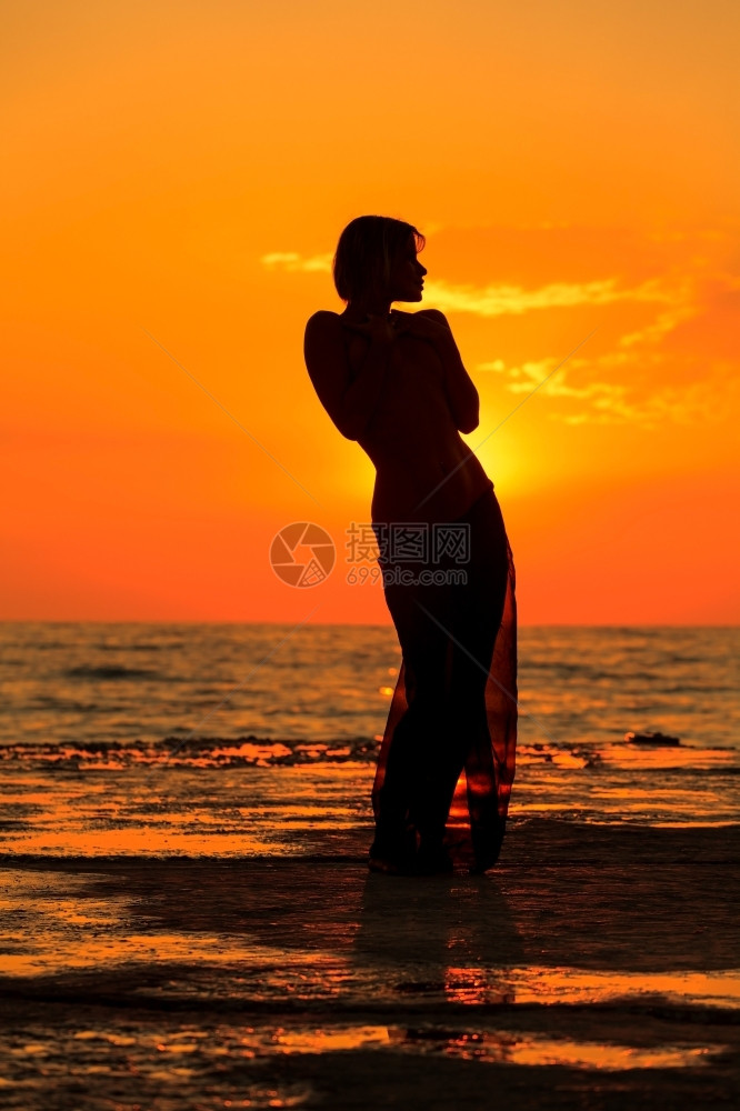 日出在落时跳舞一个女孩在海上日落背景跳舞的西尔休埃特舞水请享用图片