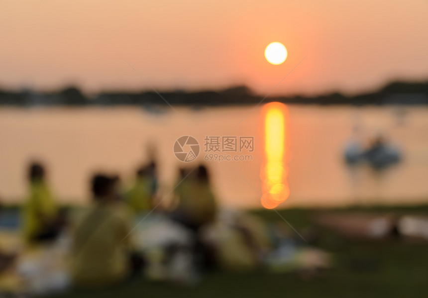 日落时在湖边野餐的模糊画面放松场地坐着图片