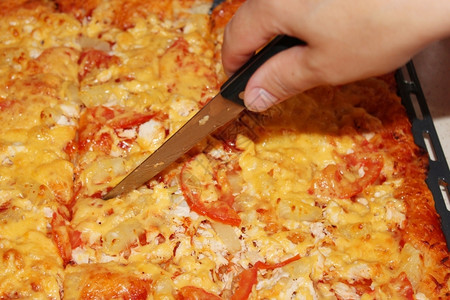 菜刀厨师切开家用子餐的比萨快稠密红色的图片