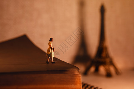 女士数字法国巴黎度假旅行的梦想目地一位微型旅游女客站在年老的书上看着埃菲尔铁塔的风气女背景图片