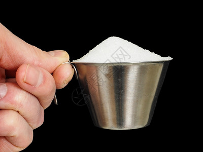 手指水晶一个人拿着含白颗粒糖用黑色隔绝的积层加满白颗粒糖金属图片