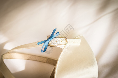 白色婚鞋上的蓝色蝴蝶结特写图片