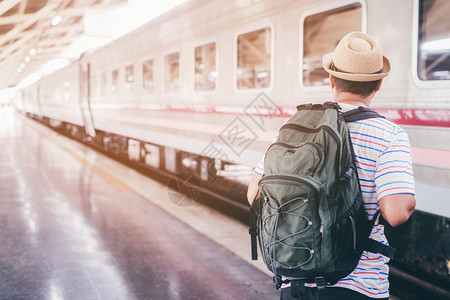 旅发大会乘客们正在等待站台平年轻男子旅行者带着背包等待火车的旅客出行准备发概念候客之旅瓜拉纳皮看不见得到背景