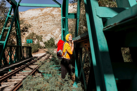 独自的妇女探索道路和一座旧铁路桥旅游黄色的图片