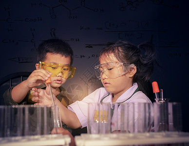 女微笑孩子科学检查实验室中的亚洲儿童人数占年图片