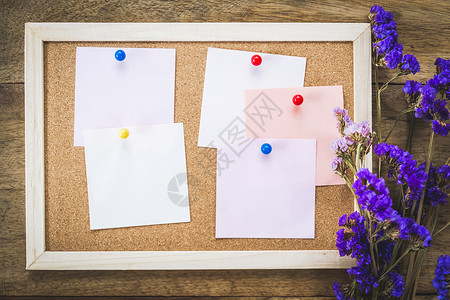 软木板上的白纸条有干鲜花束和木本底笔记信息提醒图片