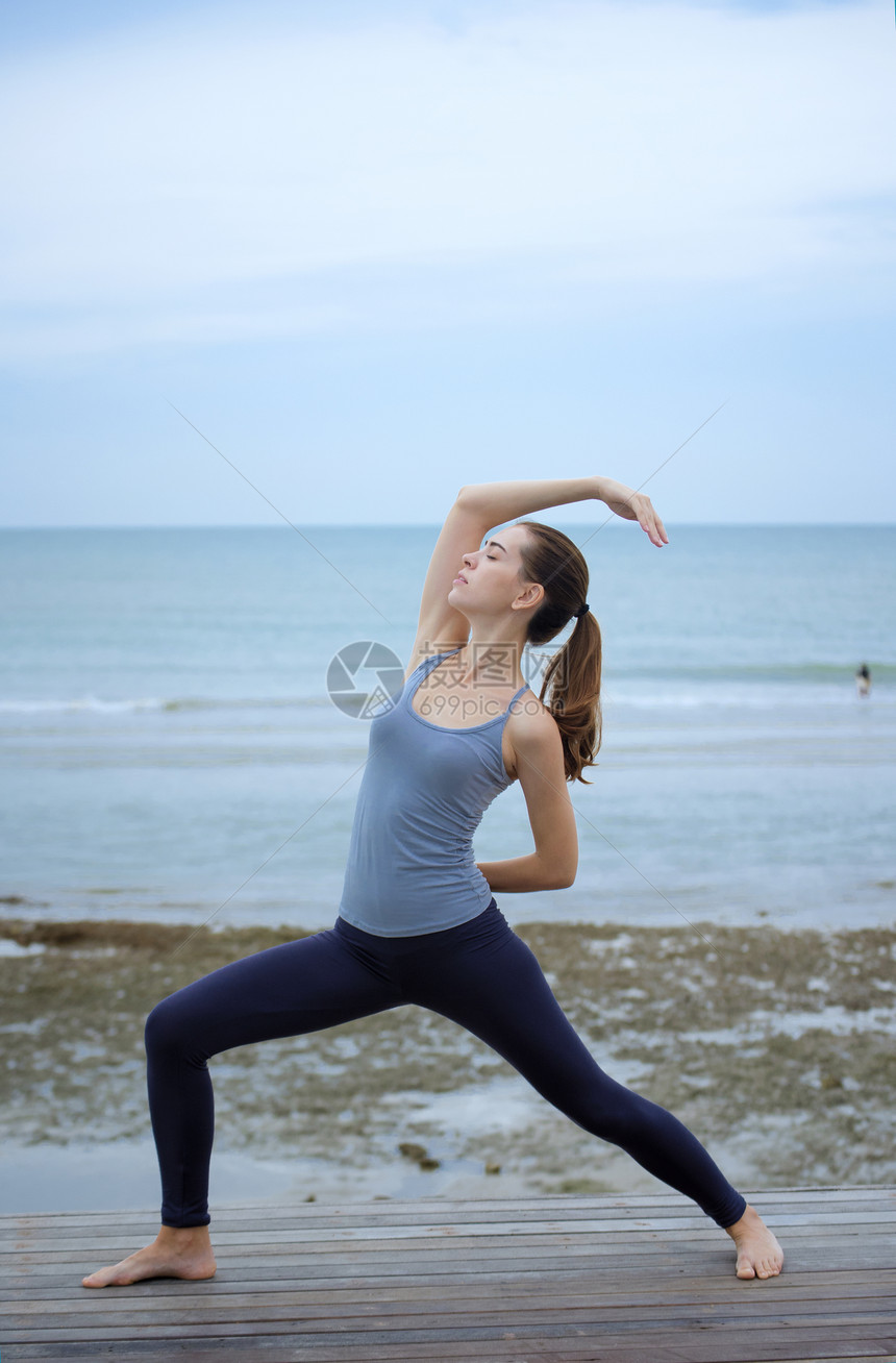 海边瑜伽的年轻女子图片