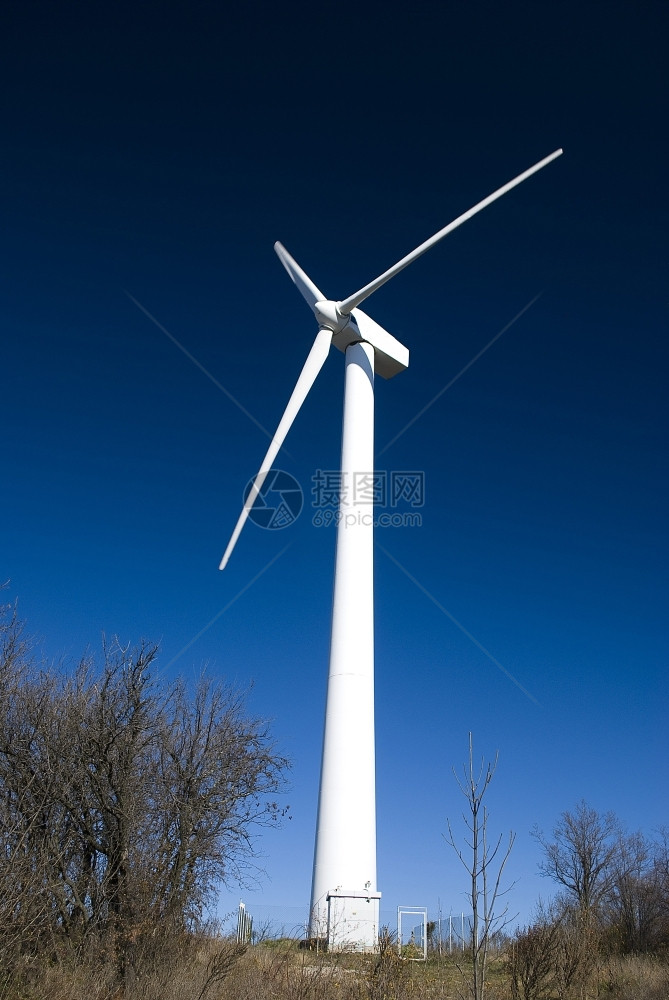 旋转风车植物面对晴蓝天空的风力涡轮机图片