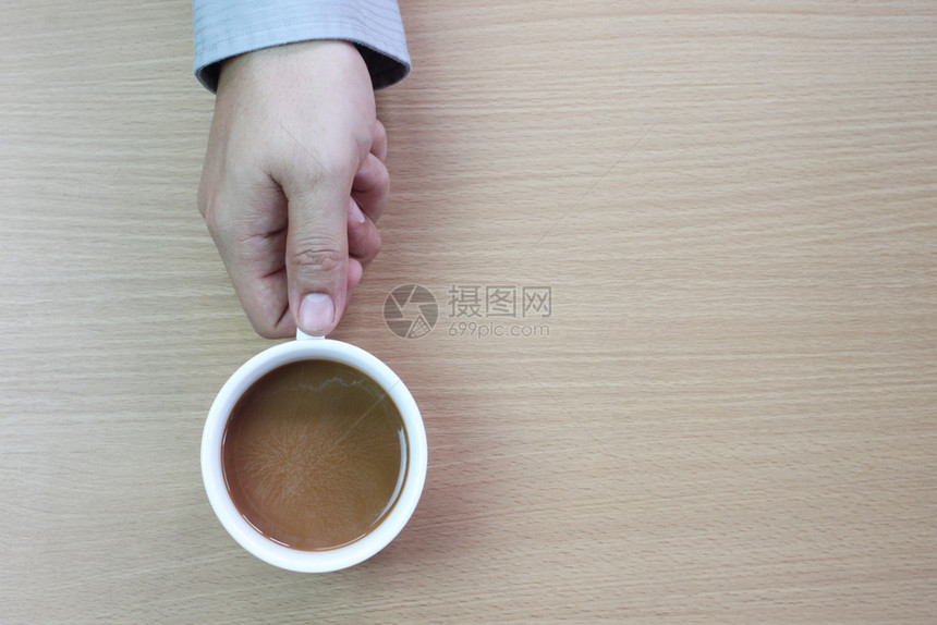 药片衬衫一位商人在棕木地板上手里的白咖啡杯复制设计空间供您使用infowhatsthis茶点图片