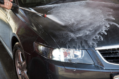 车辆冲洗机喷气式肥皂瞄准引擎盖特写照片湿的车图片