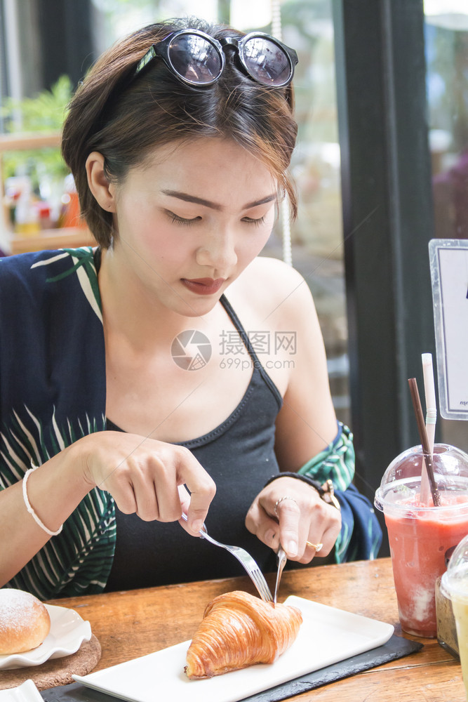 休息亚裔女脱衣羊角面包手店铺图片