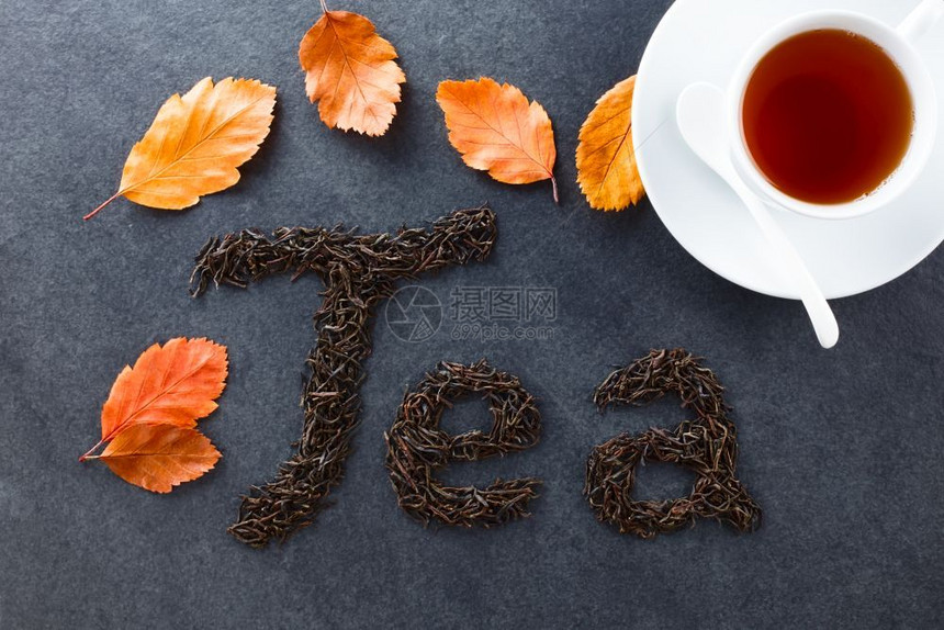 喝茶花黑在板叶秋和边的黑茶杯上拍摄了选择焦点专注字母和叶子黑茶BlackTea干燥图片