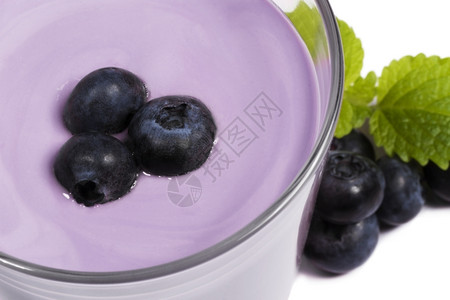 水果斯塔克蓝莓奶昔上的旁边的奶昔上的白色背景中的蓝莓和梅丽莎饮料背景图片