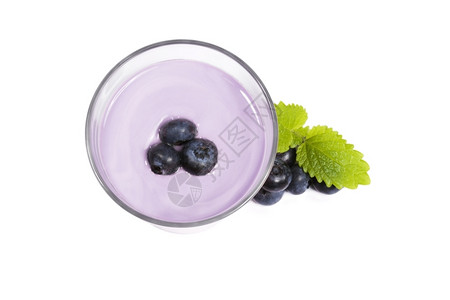 光滑的甜点蓝莓奶昔上旁边的奶昔上的白色背景中的蓝莓和梅丽莎背景图片