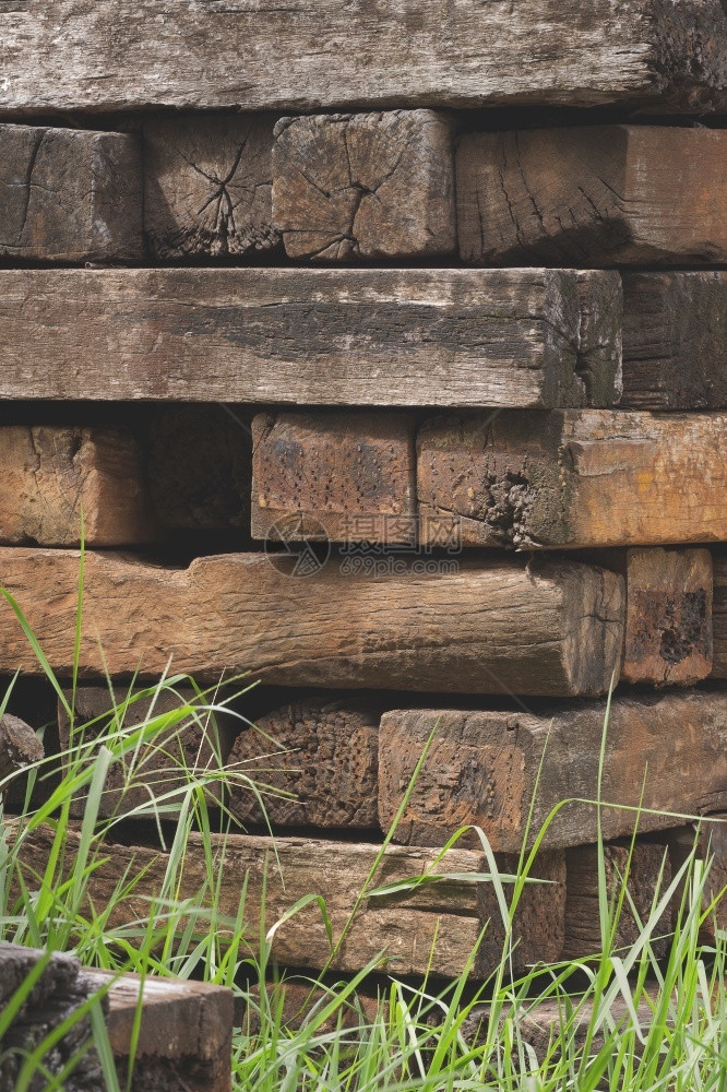 木制的堆积着许多老旧的木制铁路连接或头卧床者垂直架状地表面有模糊的草丛桩棕色图片