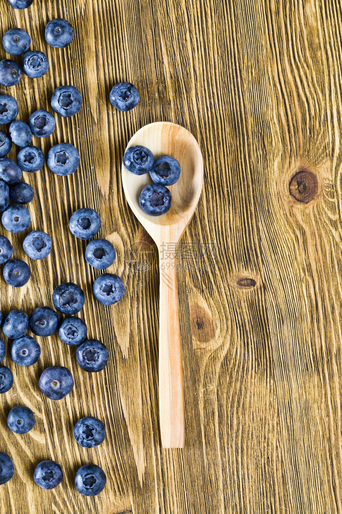 一张桌边的蓝莓夏季一张桌子上的蓝莓一张在木制桌上散布的成熟和美味果子照片一个餐桌上有生锈的木勺子食物传统的有创造力图片