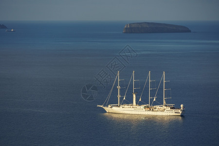 在希腊圣托里尼岛附近深蓝水域航行的帆船假期旅血管图片