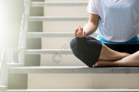 瑜伽在楼梯上紧的手健康生活方式健康身体穿着运动服家在室内人们图片