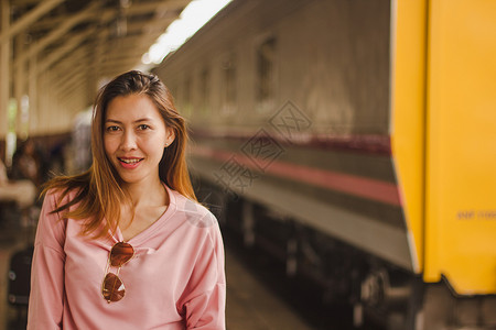 铁路妇女与火车站在一起微笑立图片