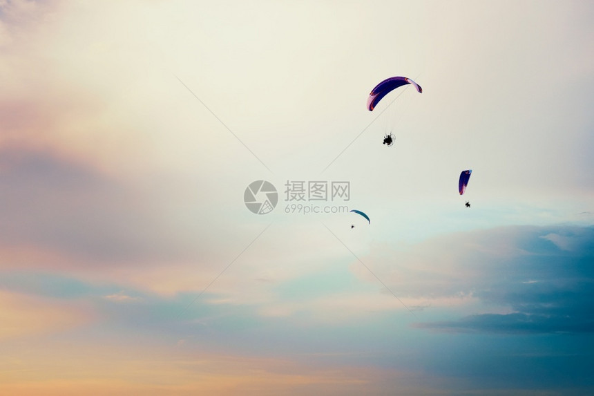 勇气滑翔伞飞行在日落极端活动业余爱好和运动的云彩色多天空中滑翔图片