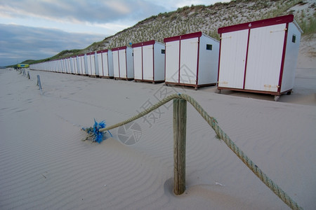 鹅卵石荷兰海滩的沙小屋英国晴天图片