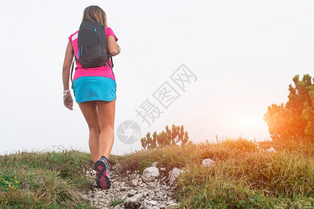 松弛景观成就带着背包在山上散步的运动妇女图片