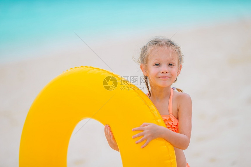 小女孩抱着黄色泳圈图片