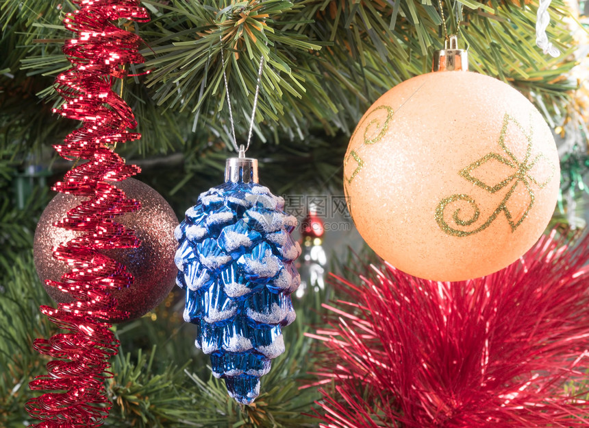 童话家庭假期在树枝和红色园地背景的树枝上圣诞球在枝上图片