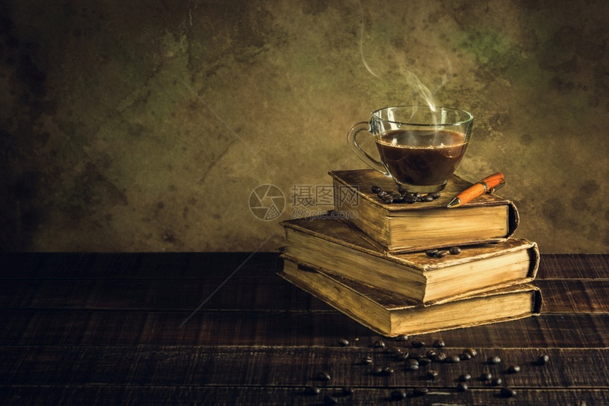 旧书和老木地板上的咖啡杯豆历史因图片