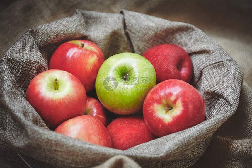 送达充满活力红苹果和绿在篮子中配有薄饼背景纹理有机新鲜苹果侧视图买图片