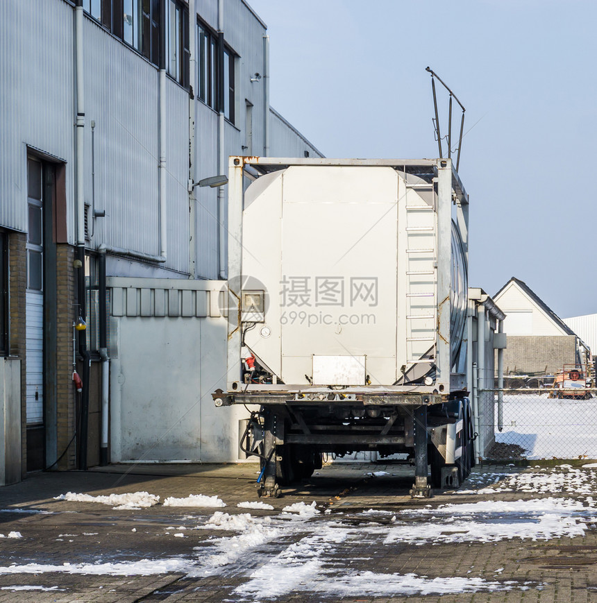 仓储预告片库门外工作场所的停在仓库门口拖车冬天图片