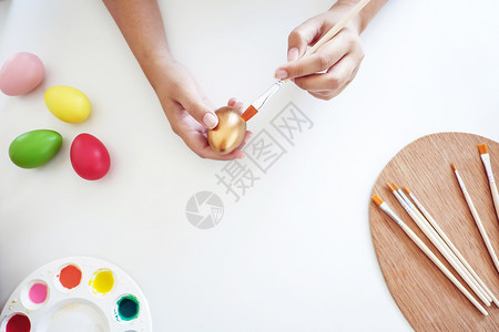 桌子快乐的手妇女用白桌绘画东方鸡蛋图片