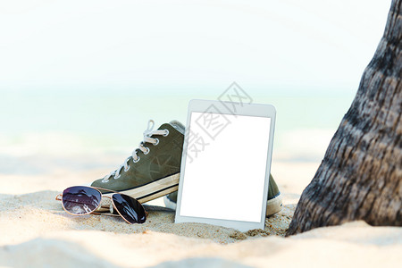 沙滩上的帆布鞋和平板电脑图片