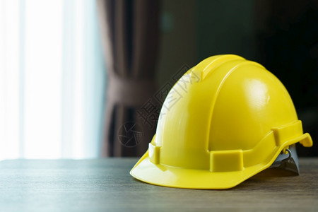 黄色头盔棕木制桌上的安全帽项目建造工业的图片