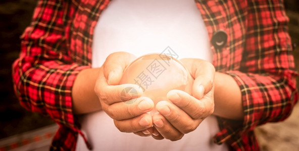 全球的亚洲女人手里握着一个神奇晶玻璃球的亚洲女人透明好奇的图片
