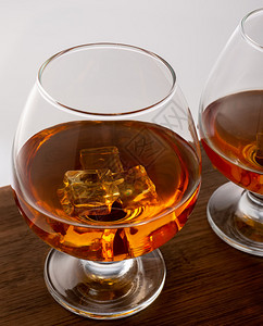 木制的玻璃清爽威士忌杯子冰贴在木制背景上威士忌杯子黑色背景上的威士忌图片