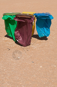 增强四个意识拒绝生态海滩上四个多彩的回收桶颜色背景