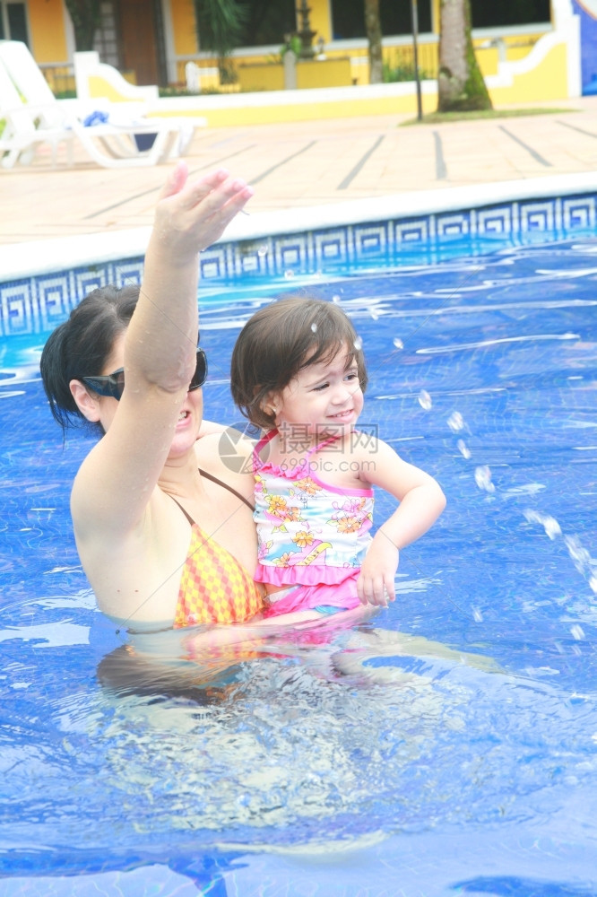 母亲和婴儿在游泳池玩卡斯蒂略乐趣湿的图片