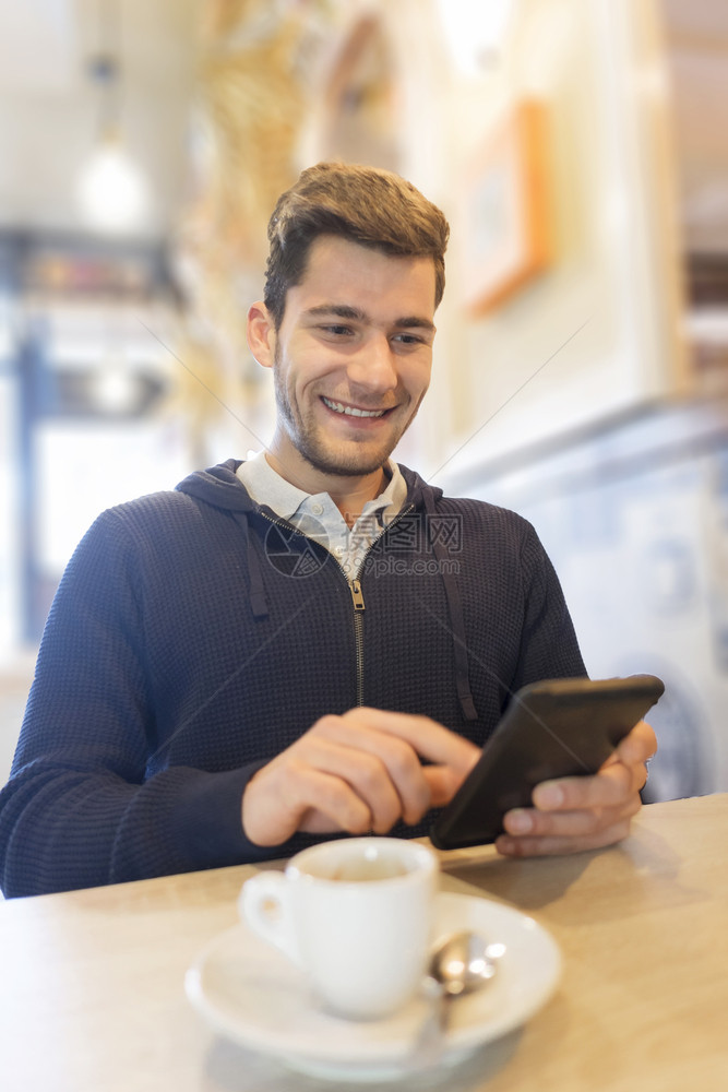 服装移动的会议在咖啡店里用智能手机的人图片