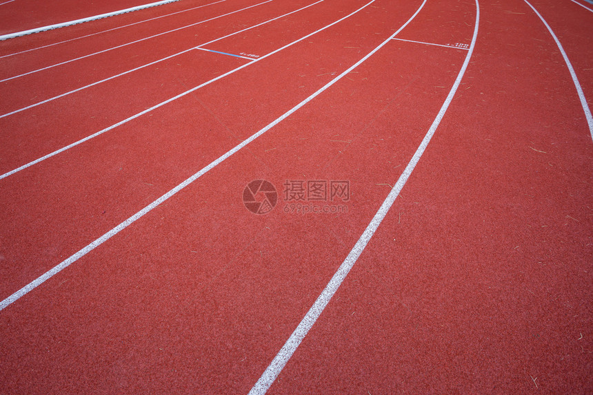 赛跑者白色的体育场线和户外体育场赛马红色橡皮道的纹身是8条田径和绿草地有白色运动场和履带追踪图片