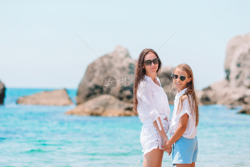 父母年轻美丽的亲和她小女儿在海滩上美丽的母亲和女儿在海滩上享受暑假滨乐趣图片