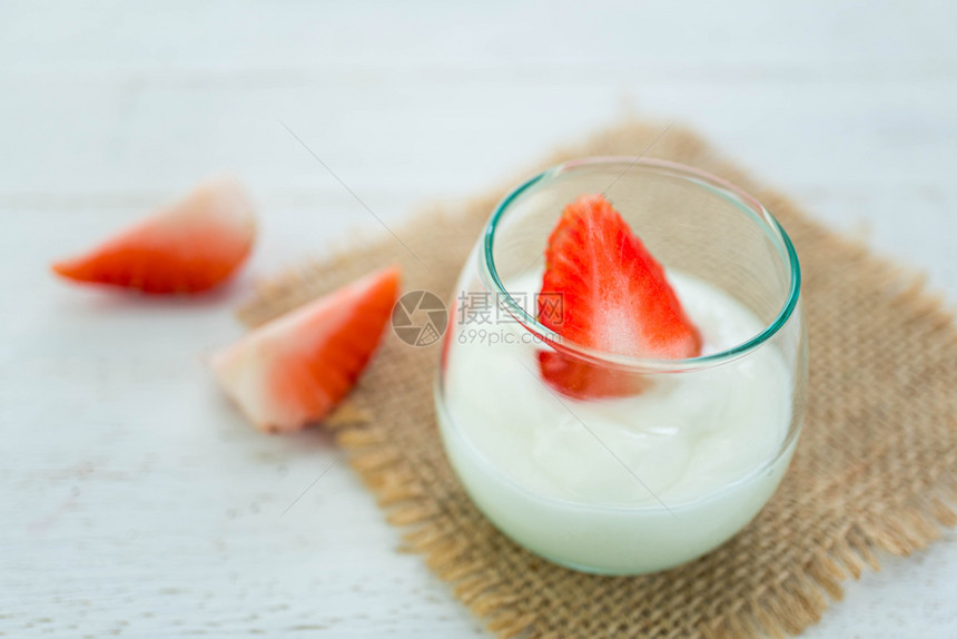 原味酸奶在白木背景上用清玻璃的新鲜草莓自然木头桌子图片