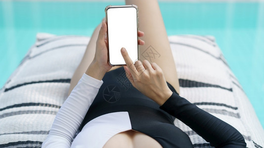 泳装女子在游池看手机屏幕背景图片