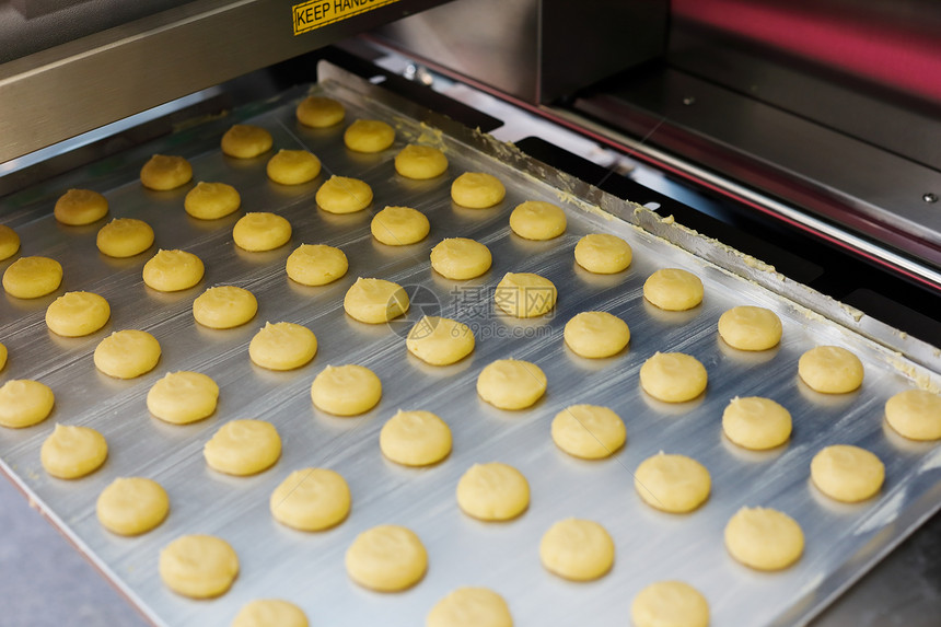 制作饼干的工业在烘烤前盘托上做曲奇饼柔软的食物制造业图片
