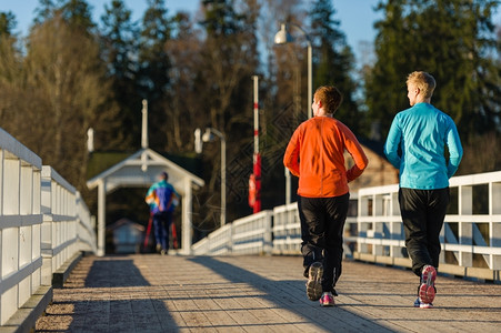 早期的运动员日出时有两个女人一起在桥上慢跑自然图片