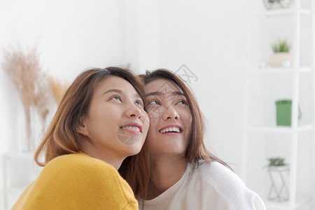 couple美丽的微笑情侣女夫妇笑着看在白床上的女Couple背景