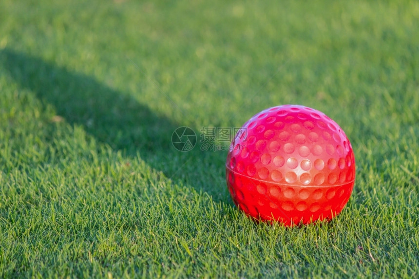 高尔夫球手闲暇红高尔夫球在草地上有夜太阳的阴影健康图片